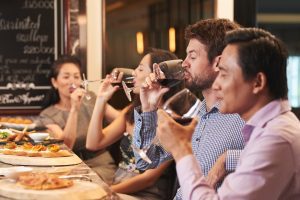 Men and women drinking red wine